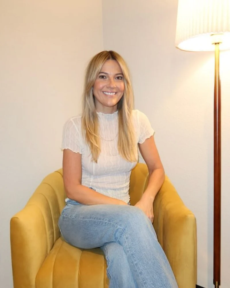 Jaime in her massage room beside a tall lamp